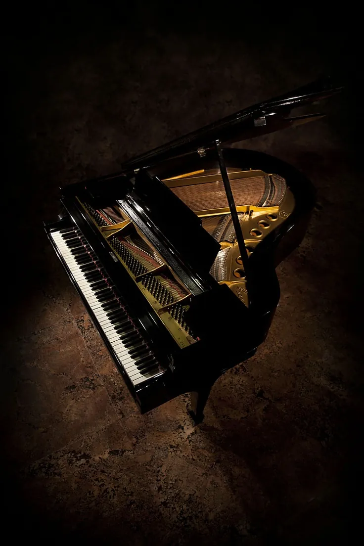 A grand piano in a dark room, seen from above